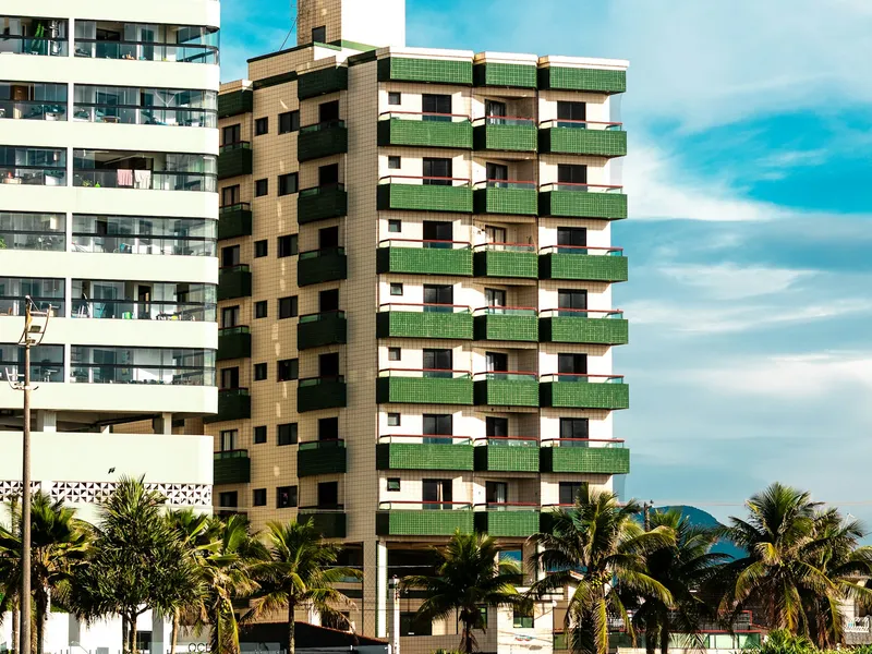 Modern condo building with balconies and palm trees